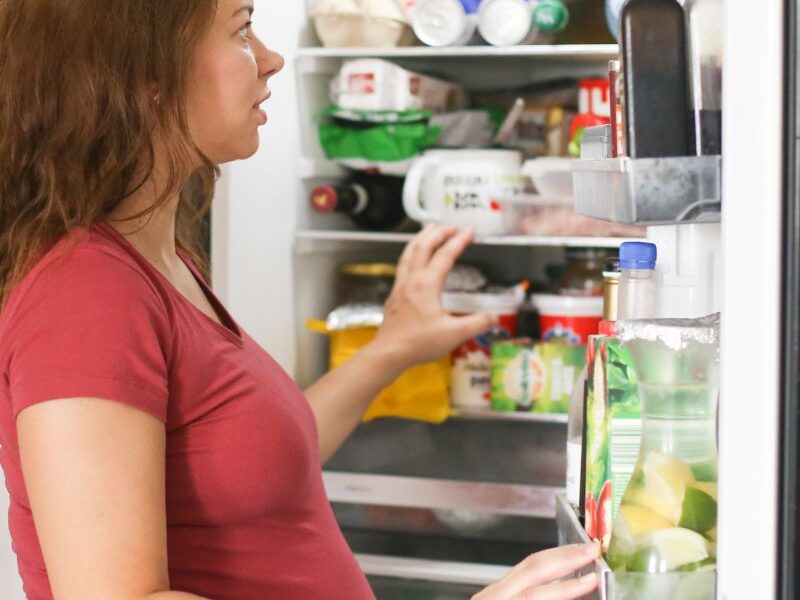 a lady taking out old food from the refrigerator