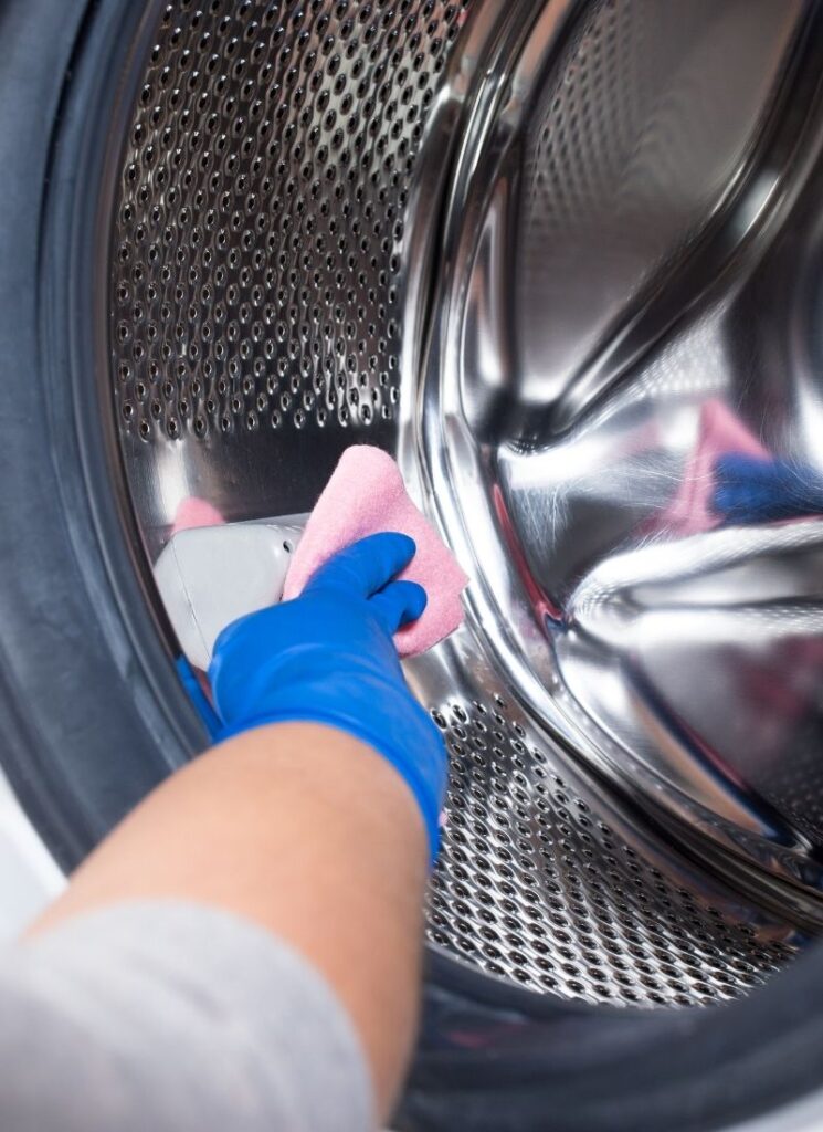 a lady cleaning her washing machine