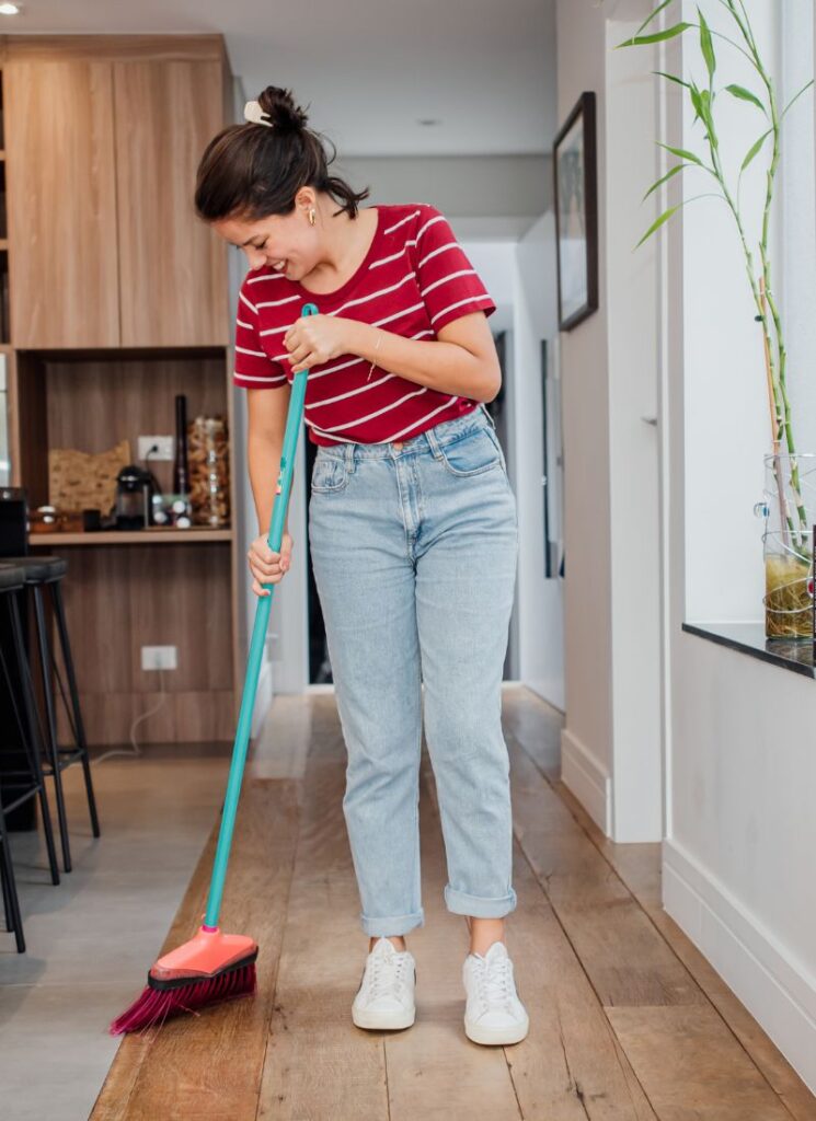 a lady sweeping the kitchen floor
