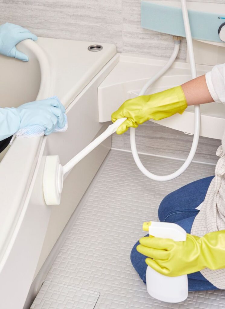 a lady wiping the bathroom tub