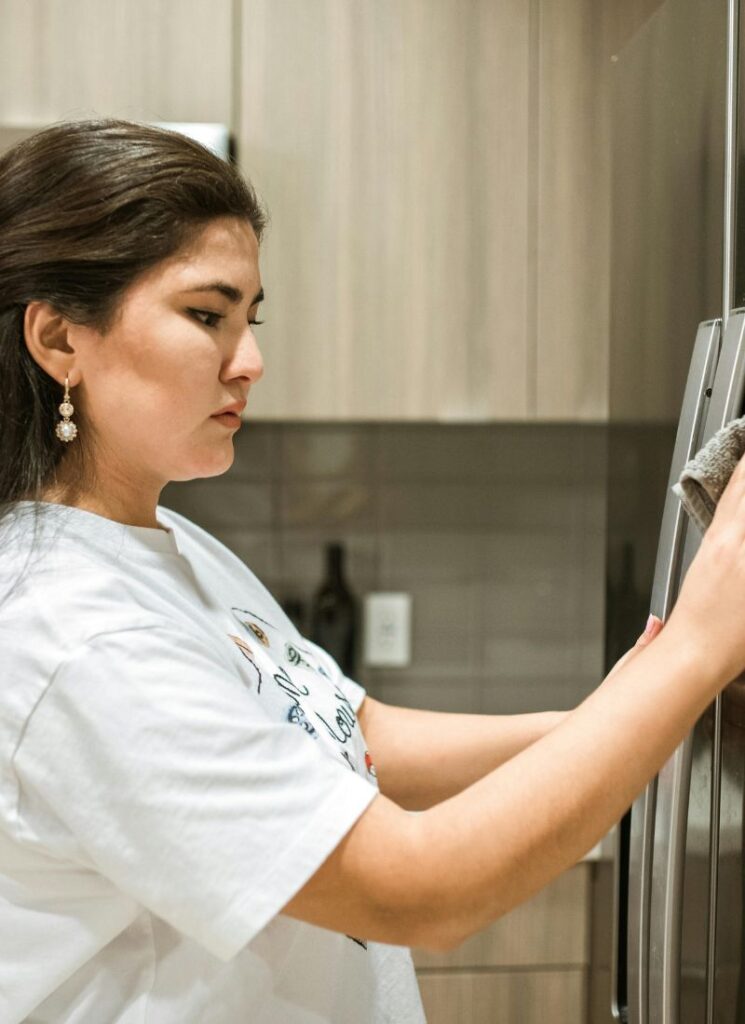 a lady clean the refrigerator